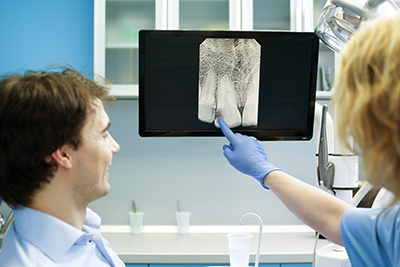 Dentist reviewing a digital x-ray with a patient.